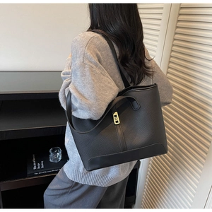 Détail du sac cabas en cuir grainé noir avec boucle métallique et bandoulière chic