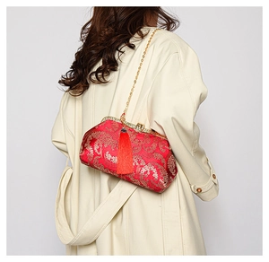 Détail du sac brodé chinois rouge avec motifs floraux dorés et pompons en soie
