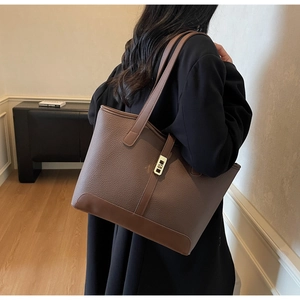 Gros plan du sac cabas en cuir marron avec boucle rotative en métal doré élégante
