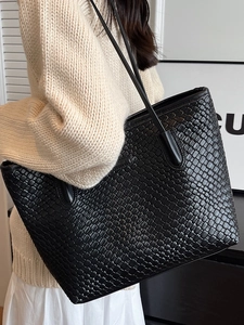 Large black woven leather tote bag for women with minimalist shoulder strap design