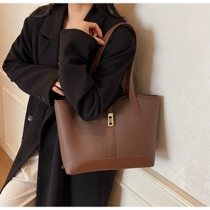 Détail d'un sac cabas en cuir marron avec un fermoir rectangulaire doré élégant