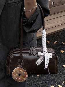 Retro deep brown shoulder bag with contrast stitching and lace bow detail on a model