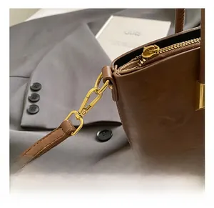 Detail of premium gold metal hooks and zipper on vintage brown leather handbag