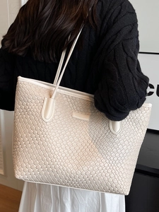 Minimalist creamy white woven tote bag with slim straps shown on model for daily commute