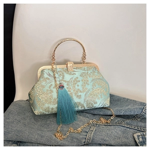 Close-up of Chinese embroidery shell bag with gold ring handle and blue silk tassel