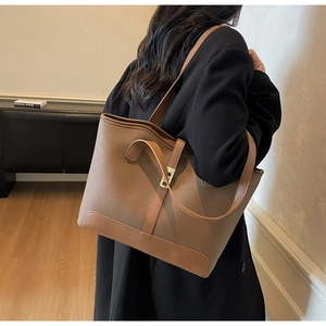 Vue détaillée du sac cabas en cuir marron avec fermoir métallique et longue bandoulière fine