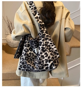 Detail showing the large leopard print tote bag with adjustable wide strap and matching pouch