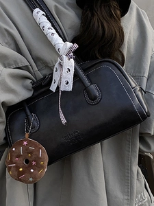 Chic black leather boston bag with contrast stitching and donut charm for women