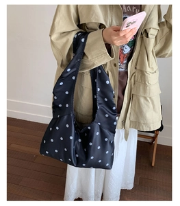 Detailaufnahme einer silbernen gepunkteten Satin-Tote-Bag an einem Model im Alltag