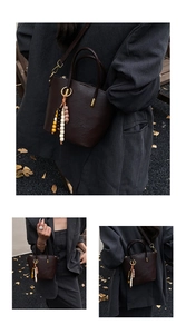 Detail of dark brown vintage handbag with colorful bead charms and zip closure