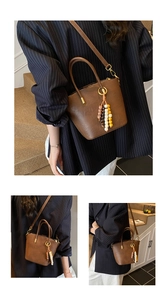 Close-up of brown leather bucket bag featuring colorful beaded tassel charm and handles