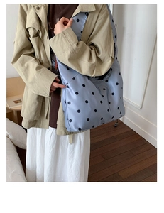 Detaillierte Nahaufnahme der hellblauen Satin-Hobo-Tasche mit großen schwarzen Punkten