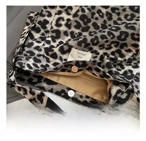 Macro shot showing magnetic snap closure and leopard print canvas texture on tote bag