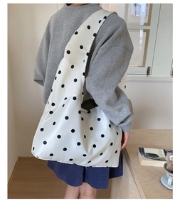 Detailansicht der weißen Satin-Einkaufstasche mit schwarzen Punkten und breitem Riemen