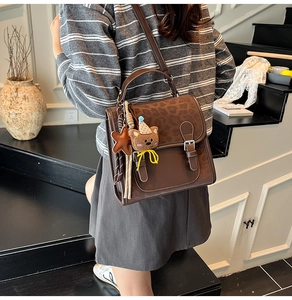 Detail of vintage brown crossbody bag with leopard print flap and plush bear charm
