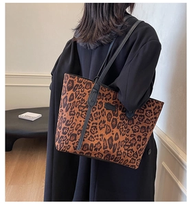 Detail of leopard print tote bag featuring black slim straps and spacious interior design