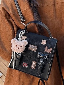 Large black matte crossbody bag with cartoon patches and a plush bear pendant