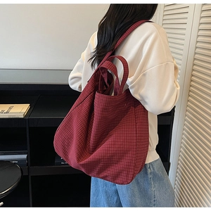 Gros plan sur un sac cabas rouge à carreaux en tissu souple avec de longues anses