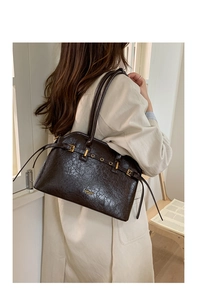 Détails du cabas vintage en cuir ciré avec finitions dorées et logo embossé