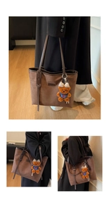 Detail of a brown suede tote bag with leather straps and a cute plush bear pendant