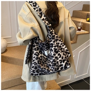 Close-up of leopard print canvas tote bag with adjustable strap and small zipper pouch