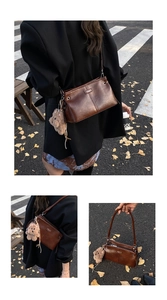 Detail of dark brown faux leather crossbody bag with a plush bear charm on autumn street