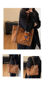Detail of brown suede tote bag with leather tag and cute plush bear charm accessory