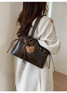 Détail du sac cabas vintage en cuir ciré marron avec breloque ours et boucles métalliques