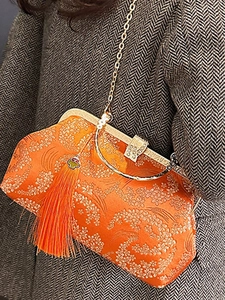 Elegant orange silk shell bag with Chinese floral embroidery, tassel, and gold chain strap
