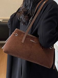 Brown suede tote bag for women featuring slim shoulder straps and metallic side eyelet detail