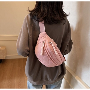 Detail der rosa gesteppten Nylon-Brusttasche mit Textur und Web-Reißverschluss am Modell