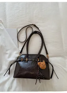 Détail du sac cabas marron vintage avec pendentif ours en peluche et boucles métalliques