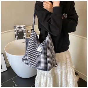 Detail of checkered tote bag with Sunshine and Blossom label in a home lifestyle setting