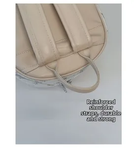 Détail des bretelles renforcées et de la poignée sur sac à dos beige pour charge lourde