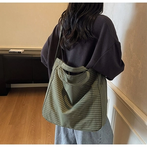 Vue arrière d'un modèle portant un sac cabas en toile à carreaux verts dans une pièce rétro