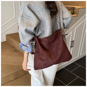 Detail view of burgundy suede tote bag with zebra print scarf strap on shoulder