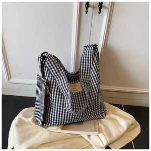 Close-up of black and white checkered canvas tote bag with matching side zipper pouch
