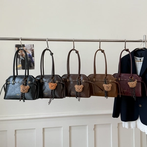 Vue détaillée de cinq sacs cabas en cuir ciré avec pendentifs ours et logos dorés