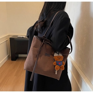 Brown vintage suede tote bag with long tassels and a cute teddy bear charm on shoulder