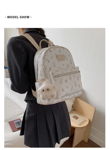 Mannequin portant un sac à dos beige à motifs lapins et breloque étoile en peluche
