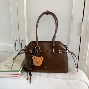 Détail du sac en similicuir marron foncé avec pendentif ours et foulard en soie