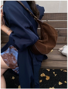 Sac demi-lune rétro en daim marron avec bandoulière réglable dans un décor d'automne