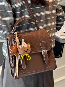 Vintage brown crossbody bag with leopard print detail and cute bear charm shown on model