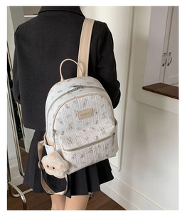 Détail d'un sac à dos blanc crème avec imprimé ours et pendentif étoile en peluche