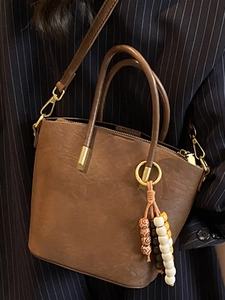 Vintage brown leather tote bag with retro pleated texture and chic beaded tassel charm