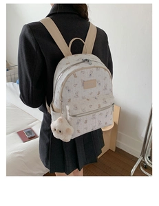 Vue arrière du sac à dos blanc avec imprimés lapins mignons et breloque peluche