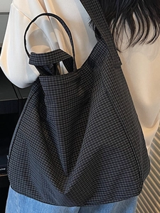 Grand sac cabas à carreaux foncés avec doubles anses porté par un mannequin en scène