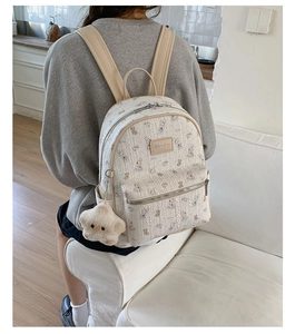 Détail du mini sac à dos blanc crème avec motif lapin et breloque étoile sur modèle