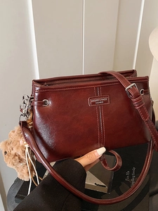 Retro burgundy leather shoulder bag with adjustable strap and cute plush bear charm