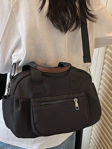Casual black nylon crossbody bag with multiple pockets and brown leather handle details